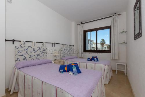マニルバにあるMarina real 223の紫のシーツが備わる客室内のベッド2台