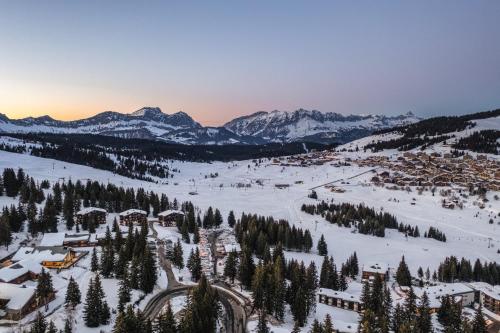 a ski resort in the snow with mountains in the background at Belambra Clubs Les Saisies - Les Embrunes - Ski pass included in Villard-sur-Doron