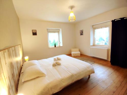 ein Schlafzimmer mit einem großen weißen Bett mit zwei Teddybären darauf in der Unterkunft Le petit Fremis / 5 Kms des pistes / axe Nancy-Thann in Saint-Maurice-sur-Moselle