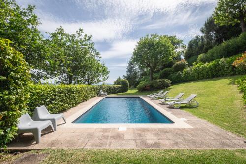 a swimming pool in a yard with lounge chairs at Casa Castel'Rei in Guimarães