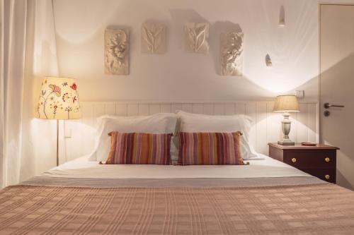 a bedroom with a white bed with two pillows at Casa Castel'Rei in Guimarães