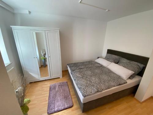 um pequeno quarto com uma cama e um espelho em FeWo Kümo an der Regnitz Bischberg's em Bischberg