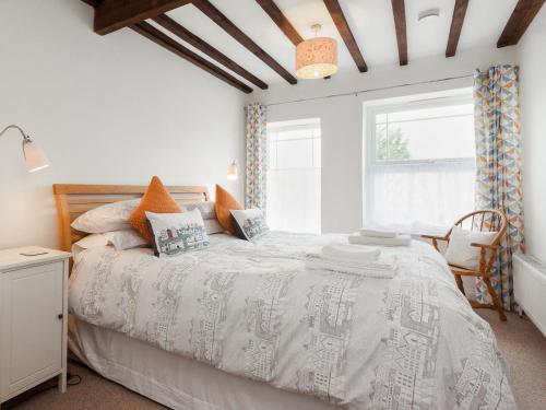 a bedroom with a bed with a white bedspread and a window at College View 2 Lower in Kingswear