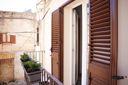 an open door of a building with plants on a balcony at La Casetta in Agrigento