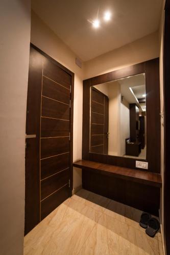 a bathroom with a wooden door and a mirror at Hotel Central Plaza in Siliguri
