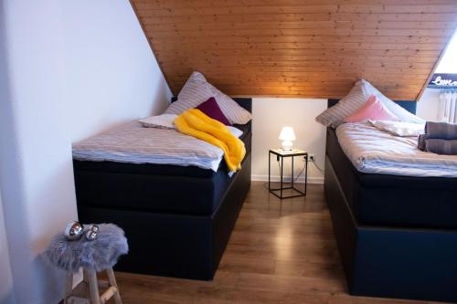 a room with two beds and a table with a lamp at Gästewohnung Mönchengladbach in Mönchengladbach