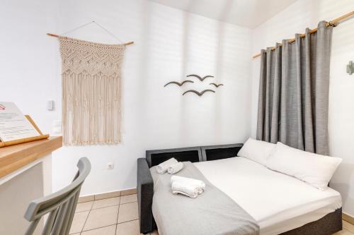 een kleine kamer met een bed en een bureau bij Cova Philoxenia House in Ermoupoli