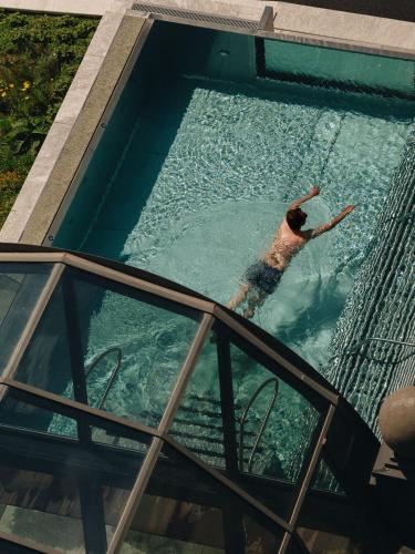 a man is swimming in a swimming pool at BEAUSiTE Zermatt in Zermatt