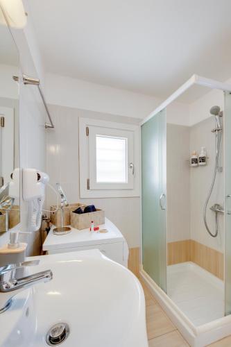 a bathroom with a shower and a sink at Cova Philoxenia House in Ermoupoli