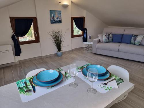 una sala de estar con una mesa con platos y copas de vino en Mansarda al mare, en Rapallo