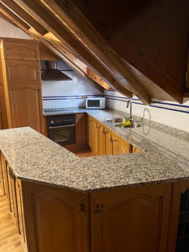 a kitchen with a granite counter top and a stove at Casa Conchita de Benasque in Benasque
