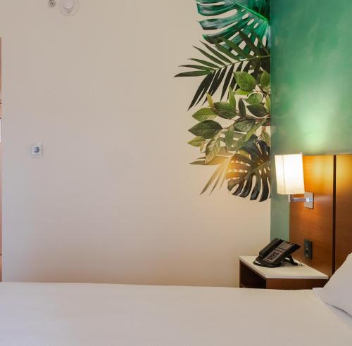 a bedroom with a bed and a phone on a table at ibis Styles Curitiba Aeroporto in São José dos Pinhais