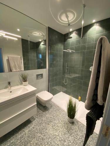 a bathroom with a toilet and a sink and a shower at May Road, stylish townhouse in Twickenham