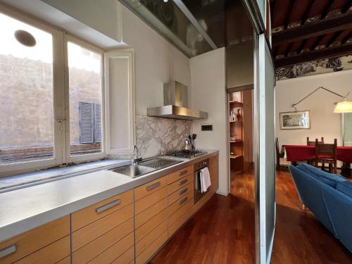 een keuken met een wastafel en een groot raam bij Guest House Bandini: eleganza nel cuore di Siena in Siena