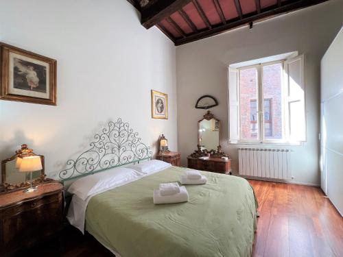 ein Schlafzimmer mit großem Bett und Fenster in der Unterkunft Guest House Bandini: eleganza nel cuore di Siena in Siena