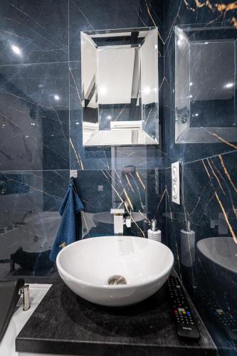 a bathroom with a white sink and a mirror at Art Styl in Białystok