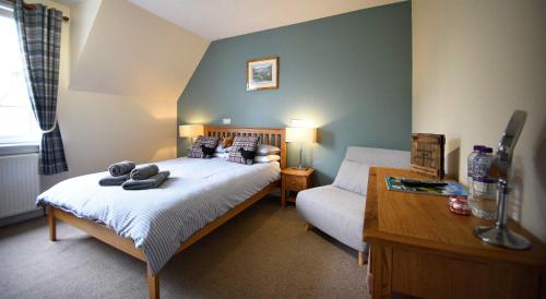 a bedroom with a bed and a couch and a table at Grenitote B&B in Portree