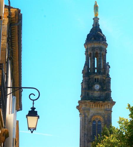 a clock tower with a statue on top of it at Première Pierre in Verdelais