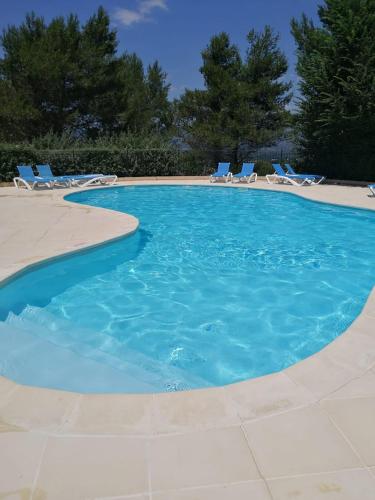 une grande piscine avec des chaises dans l'établissement Apartement Beata in Provence, Golf Pont Royal, à Mallemort