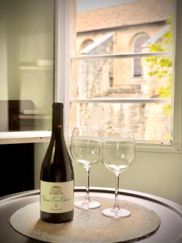 une bouteille de vin et deux verres à vin sur une table dans l'établissement Charmant Studio, Centre historique, Carmes, à Avignon