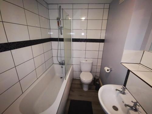 a bathroom with a tub and a toilet and a sink at City Centre Penthouse in Southampton