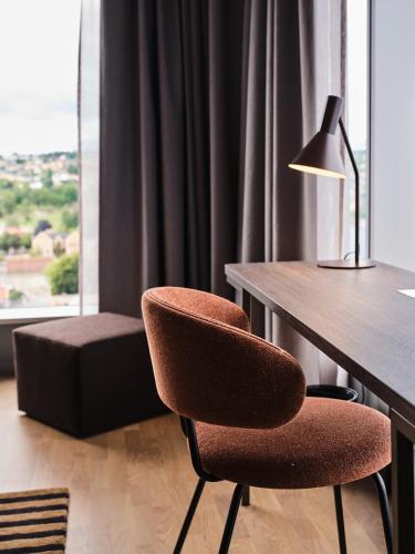 a room with a desk and a chair and a lamp at Quality Hotel Match in Jönköping