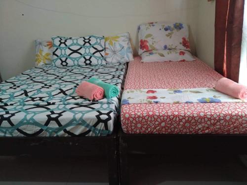 twee bedden naast elkaar in een kamer bij Kassel residences condo in Manilla