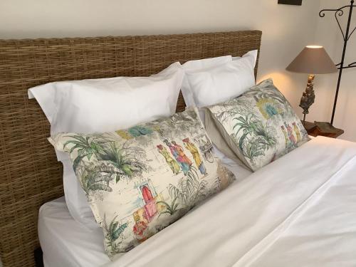 - un lit avec des draps et des oreillers blancs dans l'établissement jardin d'antan, à Ansouis