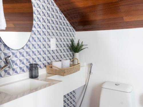 a bathroom with a sink and a toilet at Bangalô beira-mar do Marulhos Resort em Muro Alto in Porto De Galinhas