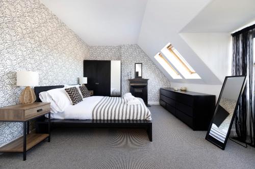 1 dormitorio con 1 cama y tragaluz en JOIVY Lovely 4 bed house, private garden and free parking, en Edimburgo