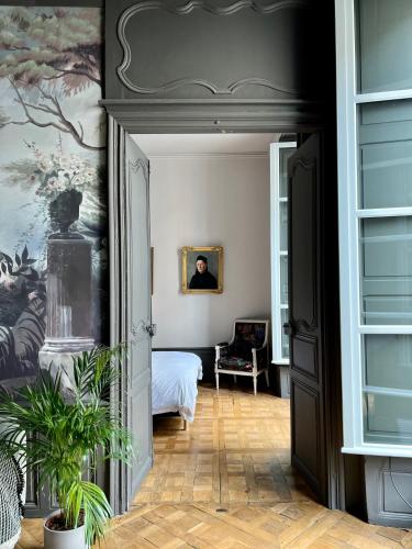 a bedroom with a bed and a painting on the wall at Luxueux 2 pièces 65m2 Hôtel Particulier XVII ième siècle-Centre Historique Clermont-Ferrand in Clermont-Ferrand
