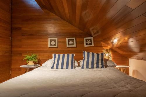 a bedroom with a large bed with wooden walls at Bangalô beira-mar do Marulhos Resort em Muro Alto in Porto De Galinhas