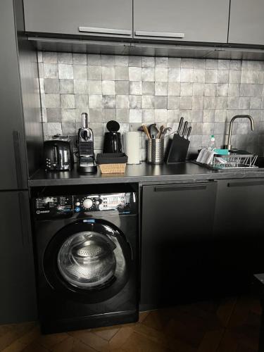 a kitchen with a washing machine in a kitchen at Luxueux 2 pièces 65m2 Hôtel Particulier XVII ième siècle-Centre Historique Clermont-Ferrand in Clermont-Ferrand