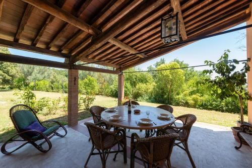 eine Terrasse mit einem Tisch und Stühlen auf einer Veranda in der Unterkunft Sur la Colline in Foglia