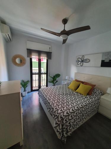 1 dormitorio con 1 cama y ventilador de techo en Tribuna Deluxe, en Málaga