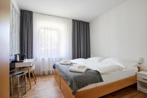 a bedroom with a bed and a desk and a window at Resort Pasecna in Přední Výtoň