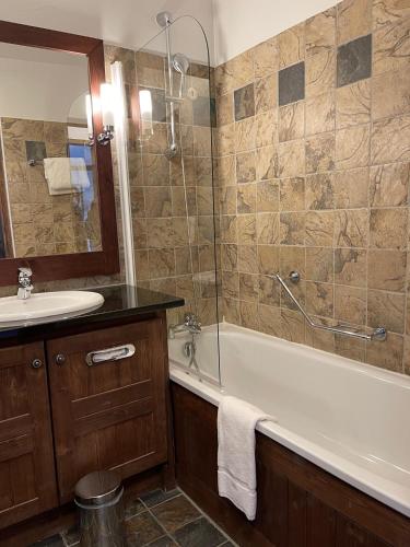 une salle de bain avec une baignoire, un lavabo et une douche dans l'établissement Appartement Arc 1950 - Manoir de Savoie, à Bourg-Saint-Maurice