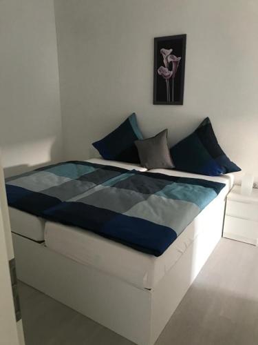 ein Bett mit einer blau-weißen Bettdecke in einem Zimmer in der Unterkunft Haus Astenblick in Winterberg für bis zu 35 Personen für Wanderveranstaltungen und Familienfeiern in Winterberg