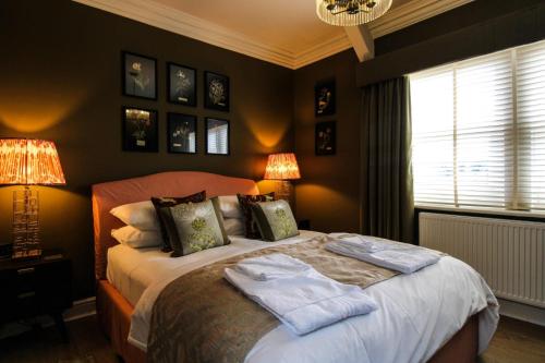 a bedroom with a bed with two towels on it at Three Horseshoes Leamside in Houghton le Spring