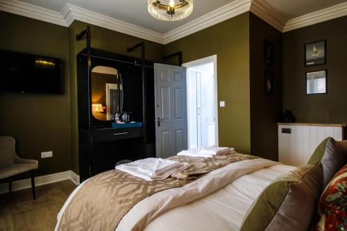 a bedroom with a bed and a window and a chandelier at Three Horseshoes Leamside in Houghton le Spring