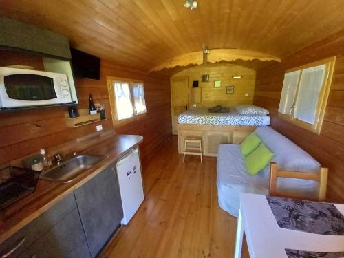 a kitchen and living room in a log cabin at L'Oasis Des Pyrénées in Campuzan