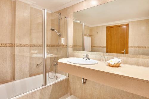 a bathroom with a sink and a shower and a mirror at Universal Hotel Castell Royal in Canyamel