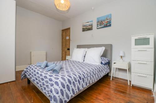 Un dormitorio con una cama con almohadas azules. en Mackerel Sky, en Penzance