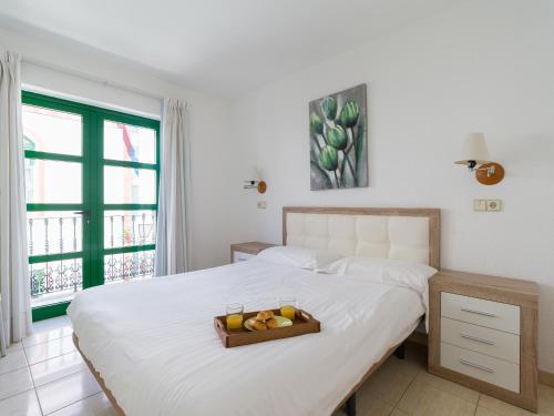 een slaapkamer met een bed en een dienblad met fruit erop bij Marina nº 289 in Puerto de Mogán