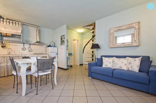 a living room with a blue couch and a table at Case Vacanze Borgo Marina IMPERIA in Imperia