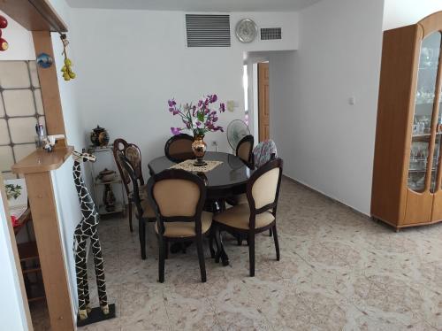 a dining room with a black table and chairs at Apartments Haagna in Ashdod
