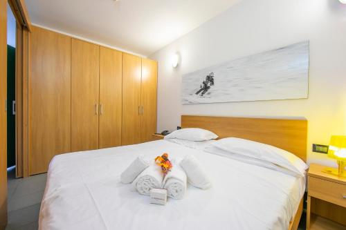a bedroom with a white bed with white pillows at Villaggio Olimpico in Sestriere