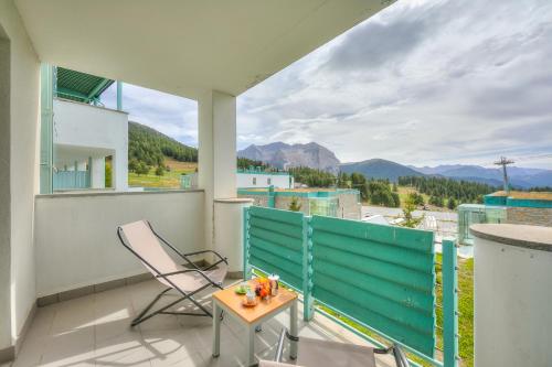 a balcony with a table and a chair and a view at Teleo 50mt From Ski Apartments - Happy Rentals in Sestriere
