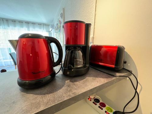 two red and black appliances sitting on a counter at Studio Aphyllante, Carnon plage, 3 étoiles in Carnon-Plage