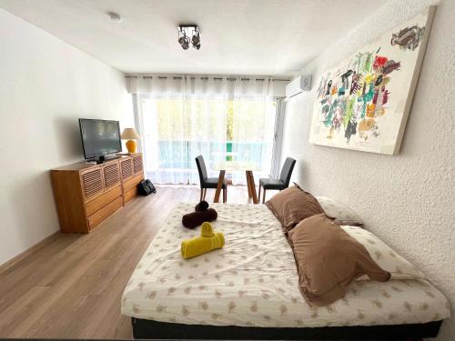 ein Schlafzimmer mit einem Bett mit einer Spielzeugente darauf in der Unterkunft Studio Aphyllante, Carnon plage, 3 étoiles in Carnon-Plage